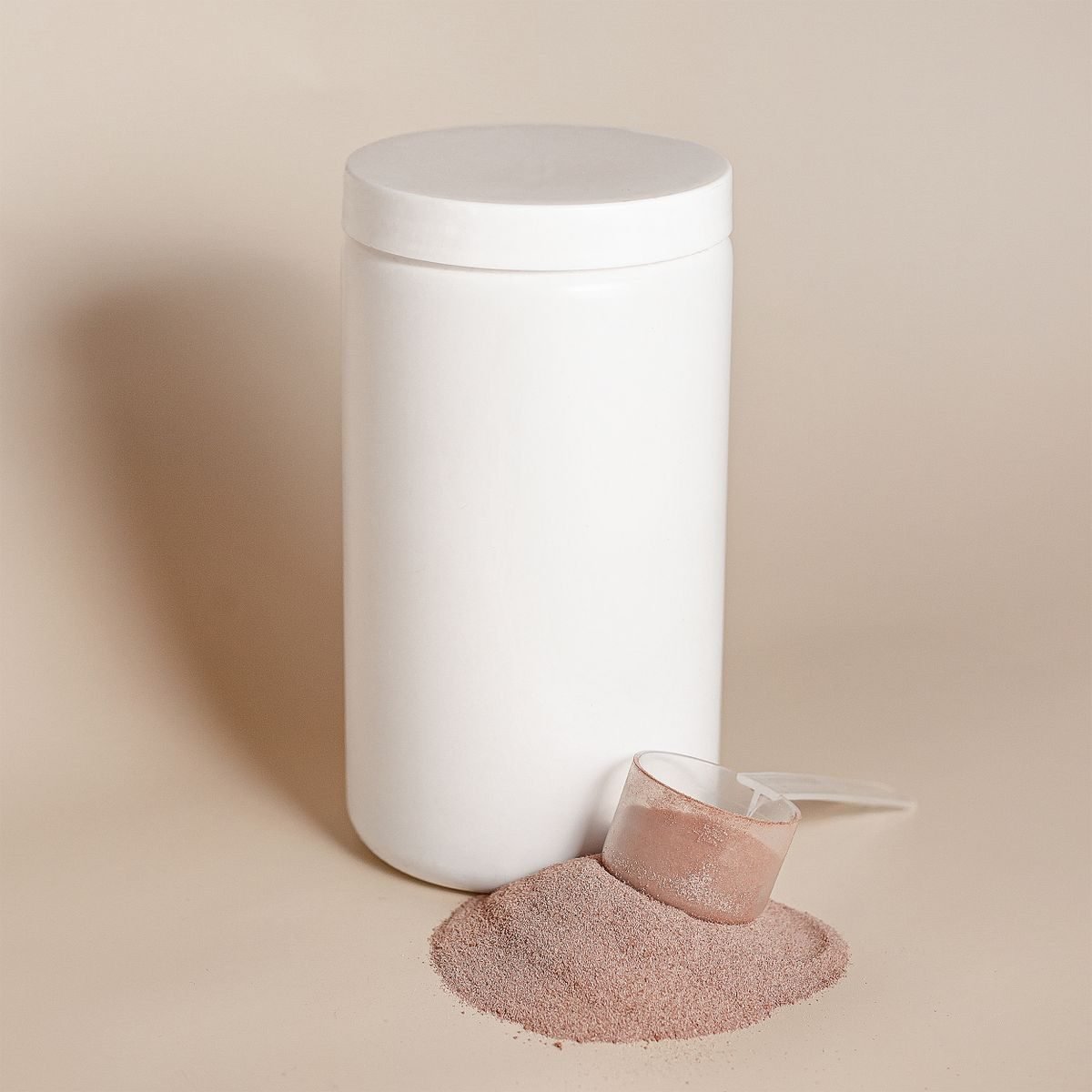 Frasco blanco sin marca con polvo y cuchara medidora sobre fondo neutro