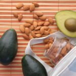Aguacates y almendras sobre un mantel de bambú